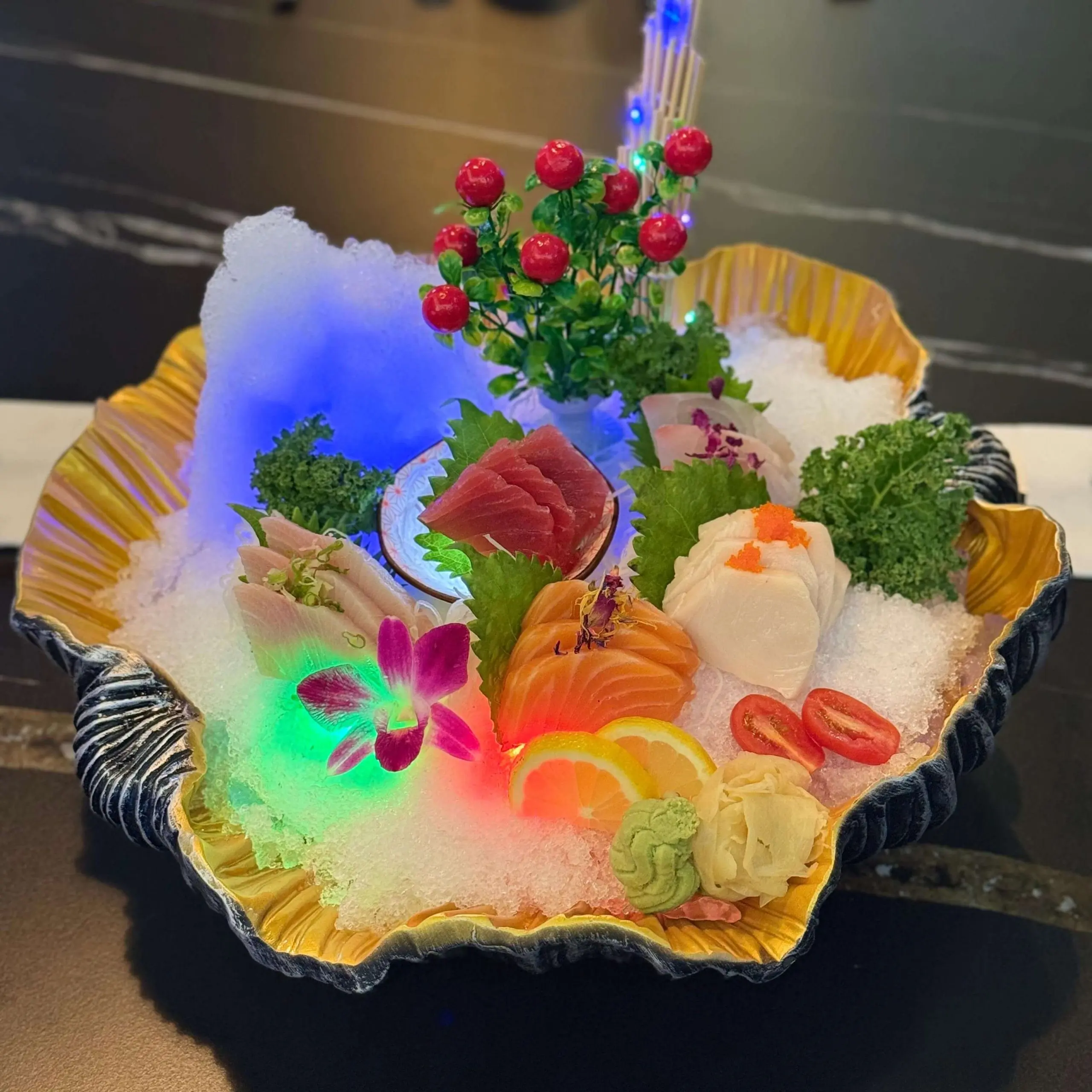 Assorted fresh sashimi on ice, with colorful fish, lemon slices