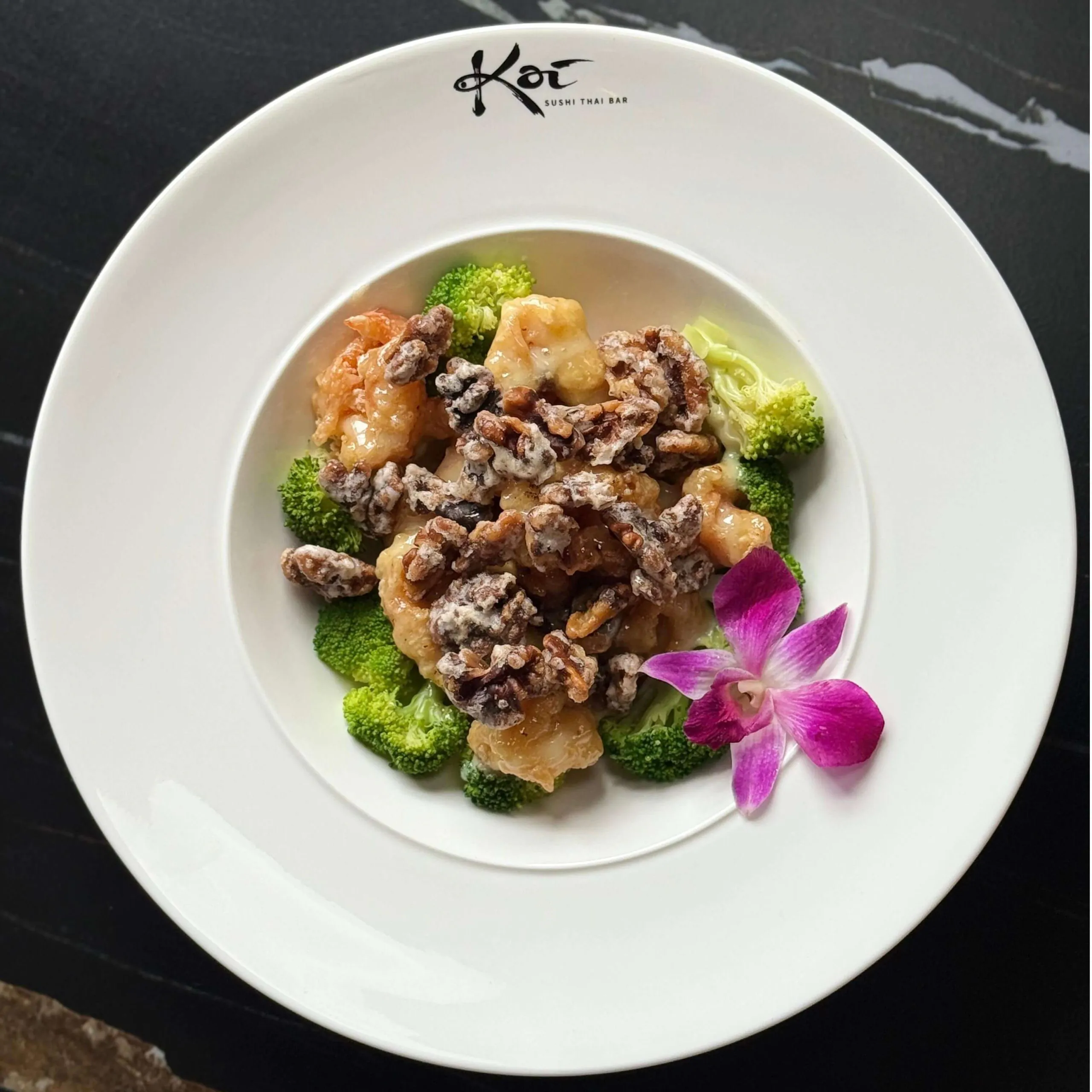 Shrimp with a creamy walnut sauce, surrounded by broccoli florets